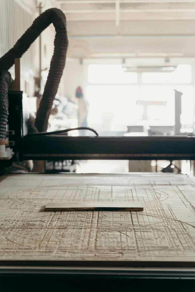 Close-up view of a CNC machine in a workshop, with a focus on the carved details.