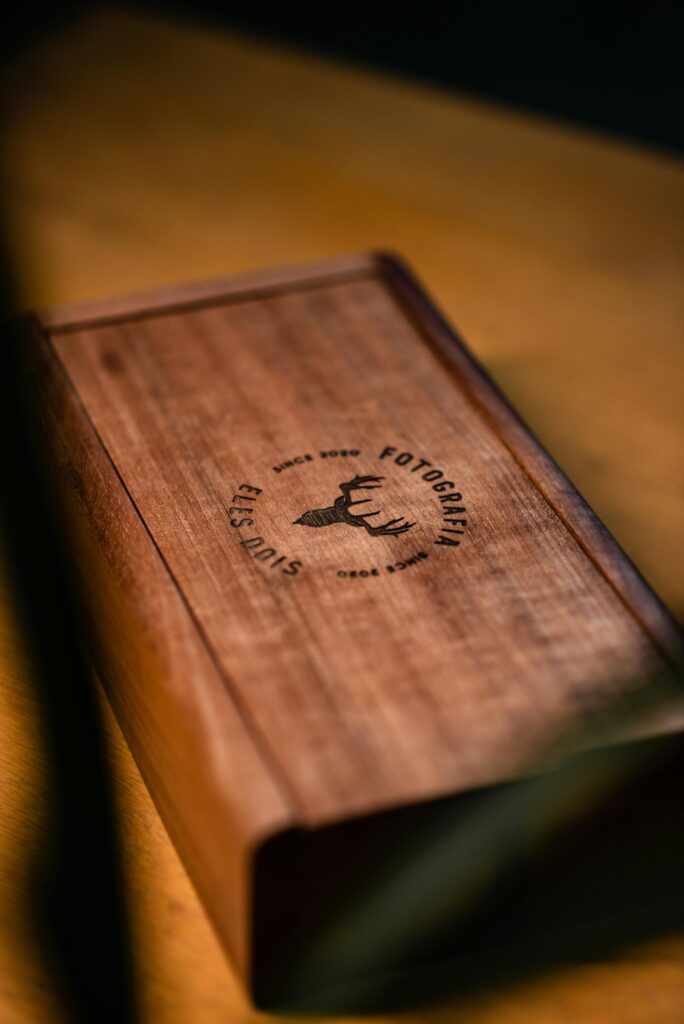 Stylish wooden box featuring an engraved logo, perfect for display or gift packaging.